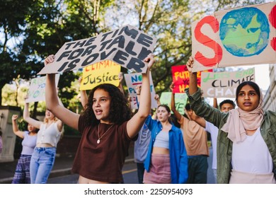 Group of teenagers standing up against climate change and global warming. Multicultural youth activists protesting with posters and banners. Diverse teenagers joining the global climate strike. - Powered by Shutterstock