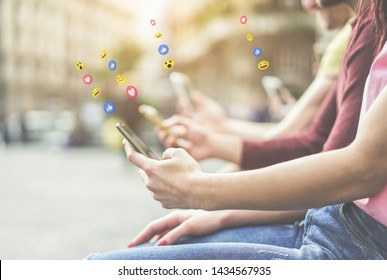 Group of teenagers using mobile phones - Young people addiction to technology trends following and chatting with emoji on smartphones - Tech and millennial concept - Focus on first hand