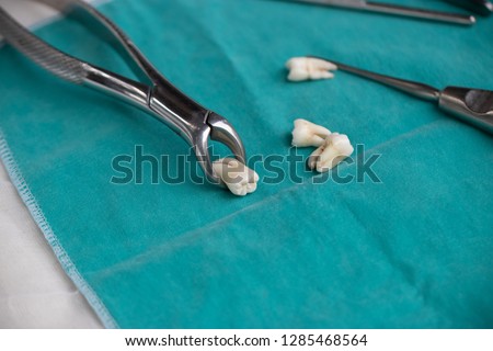 Group of teeth decay samples after tooth extraction with tools. The most common reason comes from not brushing teeth and eating sweets. Soft focus and blur. Health and problem concept.
