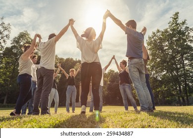 Group Of Ten Friends At The Park Holding Hands