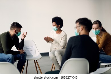 Group Therapy Participants Talking While Wearing Face Masks Due To Coronavirus Pandemic. Focus Is On African American Woman. 