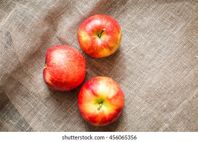 group of three apples on rustic fabric background