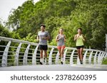 group of three asian young adult man and woman running jogging outdoors in park