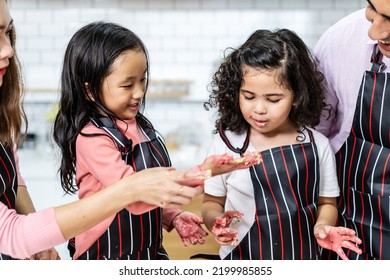 Group Of Three Diverse Family, Asian And Arab Preschool Kid Person Make Cake Cooking In Kitchen, Mom Dad And Daughter Getting Dirty With Flour While Baking Cakes Together ,Cream Mess Over Face