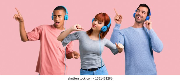 Group Of Three Friends Listening To Music With Headphones