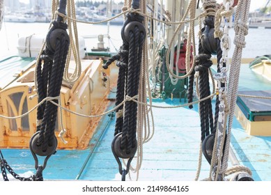 Group of three rope and block and tackle sailing rigging equipment on an old sailing barge, decking in background.