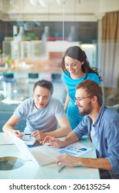 Group Of Three Successful Business Partners In Casual Working At Meeting In Office