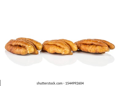 Group of three whole dry brown pecan nut isolated on white background