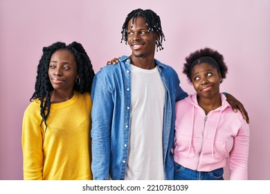 Group Of Three Young Black People Standing Together Over Pink Background Smiling Looking To The Side And Staring Away Thinking. 