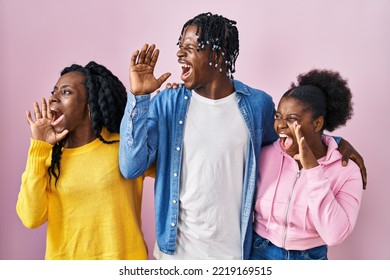 Group Of Three Young Black People Standing Together Over Pink Background Shouting And Screaming Loud To Side With Hand On Mouth. Communication Concept. 