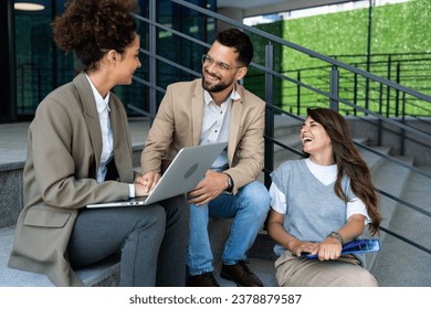 Group of three young business people experts in marketing telecommuting financial and strategy, talking outside office building. Company workers discussing strategic plans for financial crisis - Powered by Shutterstock