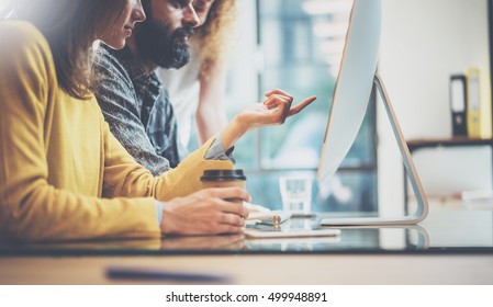 Group of three young coworkers working together in a sunny office.Man typing on computer keyboard.Woman pointing hand to desktop screen.Horizontal image,blurred background - Powered by Shutterstock