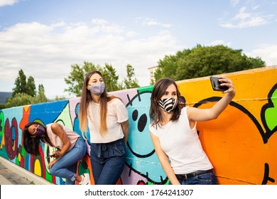 Group of three young girls having fun, taking selfie and wearing trendy face masks for protection against covid-19 coronavirus new normal concept social distancing - Powered by Shutterstock