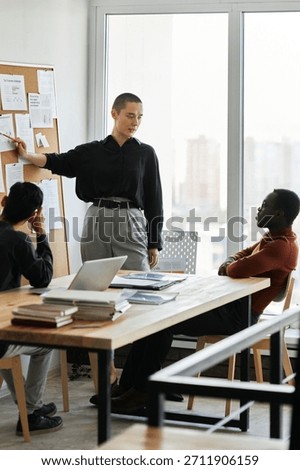 Group of three young managers working together in modern office discussing business plan and trying to predict results