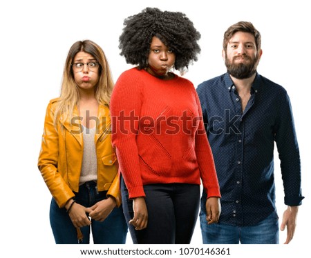 Group of three young men and women puffing out cheeks, having fun making funny face