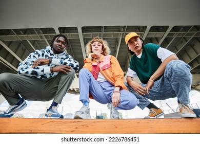 Group of three young people wearing street style clothes outdoors while sitting on stairs in urban area and looking at camera - Shutterstock ID 2226786451
