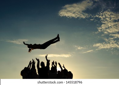 Group throwing girl in the air - Shutterstock ID 145518796