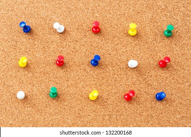 Group of thumbtacks pinned on corkboard
