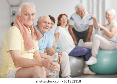 Group Of Tired Elderly People Relaxing After Workout