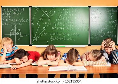 Group of tired school children at a classroom. Education. - Powered by Shutterstock