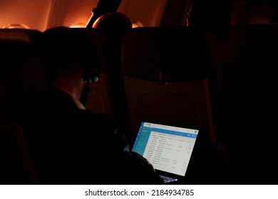 Group of tourists being seated on commercial flight trip during sunset, at night. People using online website on laptop computer and flying on aircraft with international airways, travelling.