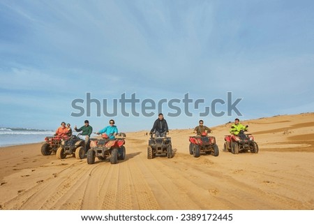A group of tourists enjoys quad biking along Essaouira's oceanfront, creating an adventurous spectacle against the scenic coastal backdrop