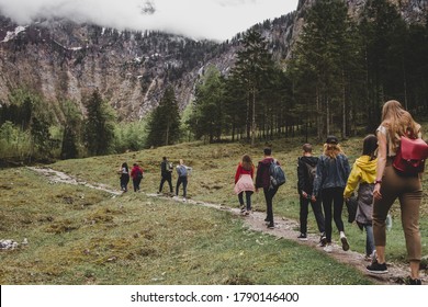 Group of tourists hike to Rothbach waterfall throw pine forest on background of rock mountains & cloud sky. Bavaria. Germany - Shutterstock ID 1790146400