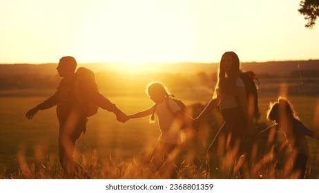 group of tourists in park. family adventure journey kid rome concept. group of family hikers silhouette walking at sunset in forest park. lifestyle backpackers traveling with backpacks - Powered by Shutterstock