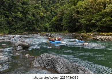 group of tourists rafting on a raft and kayak in the middle of the jungle on the Pacuare River in Costa Rica - Shutterstock ID 2287436385
