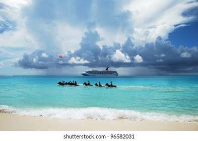 The Group Of Tourists Riding Horses In Caribbean Sea On Half Moon Cay, The Bahamas.