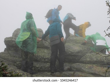 A Group Of Tourists Rises To The Top Of The Mountain In Severe Weather Conditions. Atmospheric Photo With Climbers In The Ural Mountains. National Park 