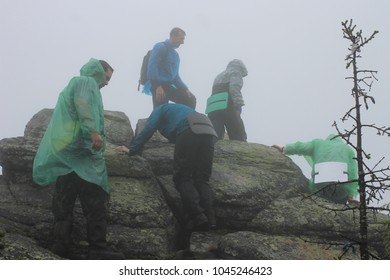 A Group Of Tourists Rises To The Top Of The Mountain In Severe Weather Conditions. Atmospheric Photo With Climbers In The Ural Mountains. National Park 