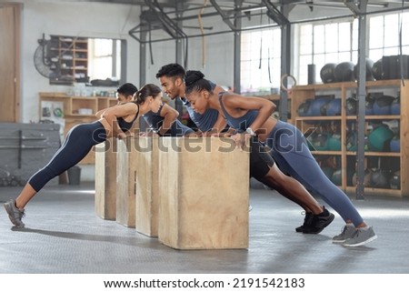 Group training, incline push up and bodyweight exercise, workout and fitness in a gym class with plyometric jump boxes. Sporty, strong and active people with endurance, energy and wellness challenge