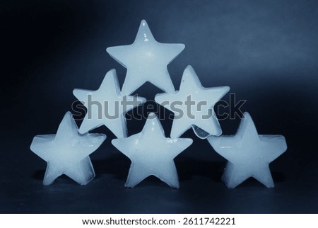 A group of translucent ice cubes stacked together against a dark background. The cool blue tones and clean composition make the image suitable for themes related to beverages, refreshment, cooling, food and drink, and summer concepts.