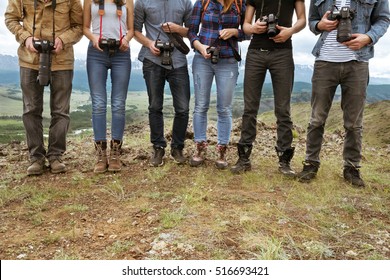 Group Of Travel Photographers Stands On Line With Cameras In Hands. Team And Teamwork Concept