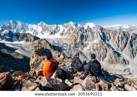 Group of trekkers climbers alpinists conquering Pik Uchitel peak from Racek Hut in Ala Archa Alpine National Park Landscape near Bishkek, Tian Shan Mountain Range, Kyrgyzstan, Central Asia.