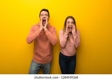 Group Of Two People On Yellow Background Shouting And Announcing Something