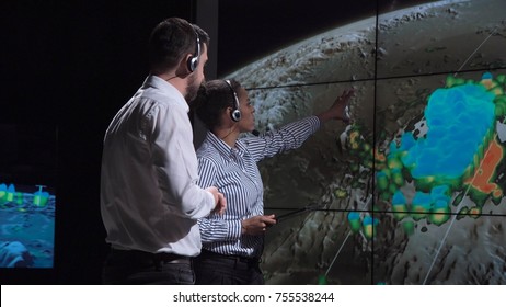 Group of two scientists observing and tracking hurricane on map and analyzing weather. Elements of this image furnished by NASA. - Shutterstock ID 755538244
