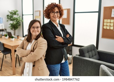 Group of two women working at the office. Mature woman and down syndrome girl working at inclusive teamwork. - Shutterstock ID 1984847762
