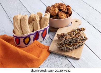Group of typical Guatemalan sweets on a light wooden background, with orange napkin with kitchen containers