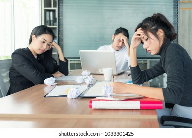 Group Of Unhappy Asian Business People In Casual Suit Sitting In Business Meeting Room And Looking Strain.