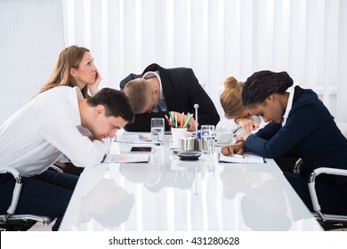 Group Of Unhappy Businesspeople Sitting In Business Meeting