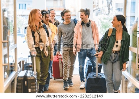 Group of university college tourist walking inside the hotel with suitcases -Young happy students enjoying summer holiday-Tourism Vacation and Lifestyle concept with people-Youth culture-Spring time