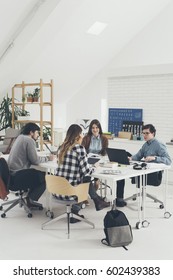 Group Of University Students Studying Together In Classroom.