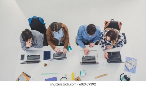 Group Of University Students Studying Together In Classroom.