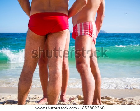 A group of unrecognizable Brazilian men wearing a style of swimwear known locally as 