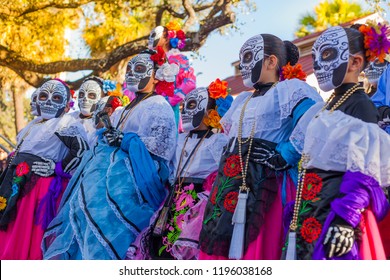 Group of unrecognizable women wearing traditional sugar skull masks and costumes for Dia de los Muertos celebration - Shutterstock ID 1196038168