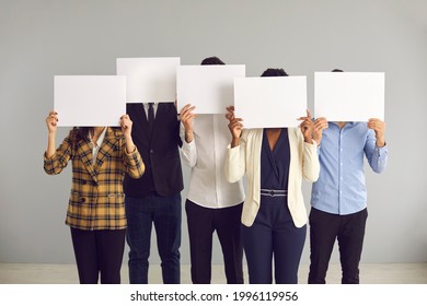 Group of unrecognizable young multiracial people covering faces hiding behind blank mockup signs. Team of anonymous multiethnic office workers holding empty white sheets of paper - Powered by Shutterstock