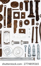 A group of various old and new bits and pieces arranged on white. Old rusty nuts, bolts, nails and other parts flay lay on white background.