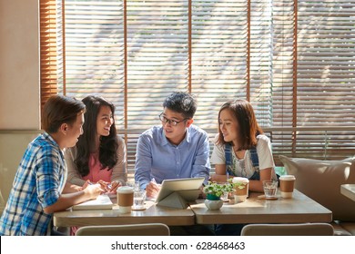 Group Of Vietnamese Friends Studying In Local Cafe